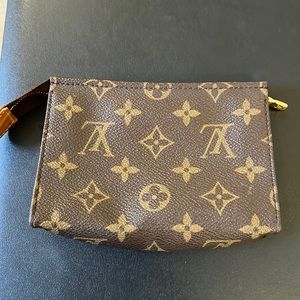 This LV item has wear and tear in the inside of the little pouch.